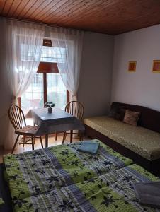 大梅杰尔Apartmán pri starom dube的一间卧室配有两张床、一张桌子和一张沙发