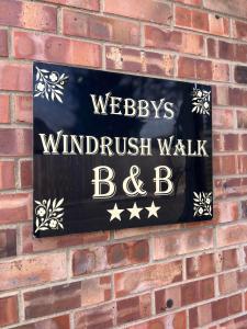 水上伯顿Webbys Windrush Walk的砖墙上的一个标志,上面写着读书的字迹