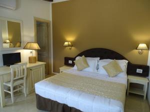 帕劳Locanda Domus De Vida Turismo Rurale的一间卧室配有一张床、一张书桌和一台电视