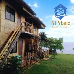 圣胡安Almare Guest House Siquijor的一座拥有楼梯的建筑,靠近大海