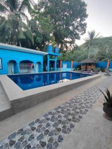 安达R&D Traveller's Inn的蓝色的房子,前面设有一个游泳池