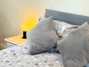 水上伯顿Webbys Windrush Walk的一张带枕头的床和一张桌子上的台灯