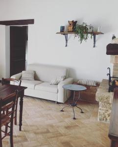 皮恩扎Agriturismo Santa Maria的客厅配有白色的沙发和桌子