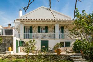 盖奥斯Vive Mar Paxos的一座带绿色百叶窗的白色旧房子