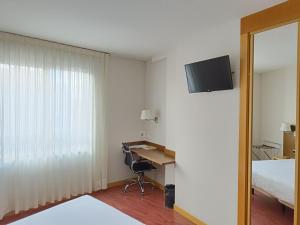 帕伦西亚国会宫酒店的酒店客房配有一张床、一张书桌和一台电视。