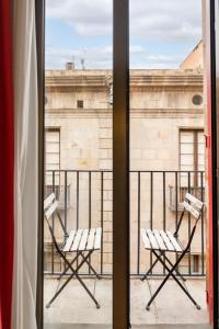 巴塞罗那Hesperia Barcelona Barri Gòtic的阳台上配有两把椅子,可从窗户眺望