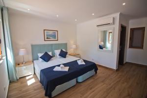 拉戈斯Casa da Ladeira Branca的一间卧室配有一张带蓝色床单和蓝色枕头的床。