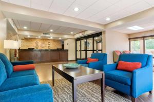 塔拉哈西Comfort Suites Tallahassee Downtown的一间设有蓝色椅子和桌子的等候室
