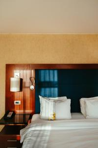 根特根特万豪酒店的一间卧室配有一张大床和蓝色床头板