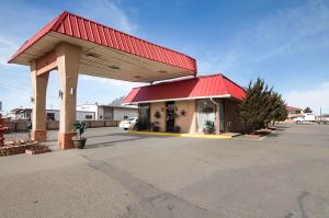 达尔哈特Econo Lodge Dalhart Hwy 54 - Hwy 287的停车场内的一个红色屋顶的加油站