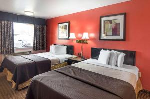 达尔哈特Econo Lodge Dalhart Hwy 54 - Hwy 287的红色墙壁的酒店客房内的两张床