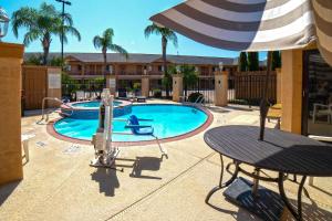 科珀斯克里斯蒂Econo Lodge Inn & Suites Corpus Christi的一个带桌子和遮阳伞的游泳池