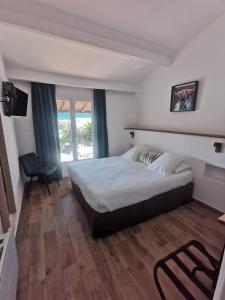 圣马迪拉莫卡马尔古埃瑟酒店的卧室配有床、椅子和窗户。