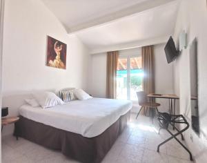 圣马迪拉莫卡马尔古埃瑟酒店的一间卧室配有一张床、一张桌子和一个窗户。