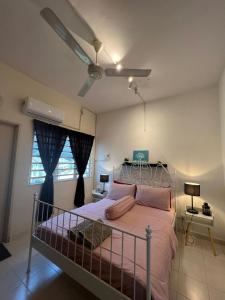 怡保Eira Homestay Lost World Of Tambun M uslim only的一间卧室配有一张带粉红色枕头的床和吊扇。