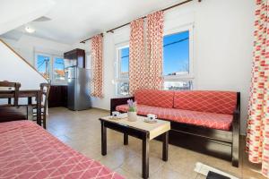 利迈纳里亚Apartments Ralitsa的客厅配有红色的沙发和桌子