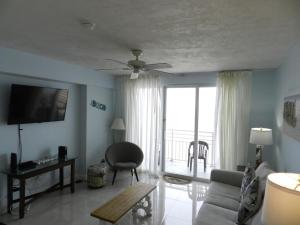 代托纳海滩1 BR Resort Condo Direct Oceanfront Wyndham Ocean Walk - Daytona Funland 1307的带沙发和吊扇的客厅