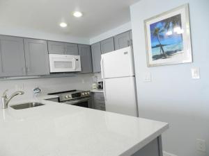 代托纳海滩1 BR Resort Condo Direct Oceanfront Wyndham Ocean Walk - Daytona Funland 1307的白色的厨房配有冰箱和水槽