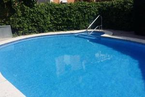 萨洛Casa adosada con piscina comunitaria Solo familias no grupos de jovenes的大型蓝色游泳池,上面有标志