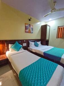 孟买Hotel Amber-colaba的蓝色和白色的酒店客房内的两张床
