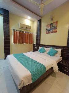 孟买Hotel Amber-colaba的一间卧室配有一张带蓝色枕头的大床