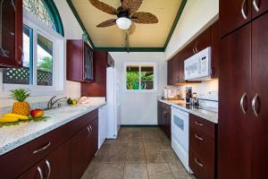 科纳The Cottage的厨房配有木制橱柜和吊扇