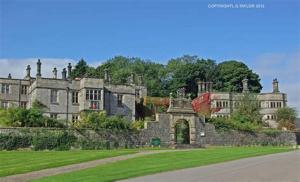 奥尔弗里顿Modern 2-Bed House and Parking Tibshelf Derbyshire的一座古老的城堡,前面有一片绿色的草坪