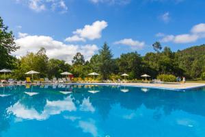 布拉加Hotel Braga Falperra的一个带椅子和遮阳伞的大型游泳池