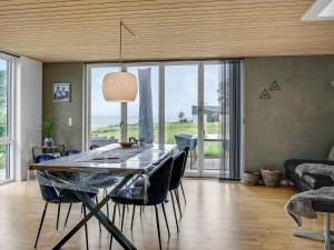 AsperupHoliday Home Anny - 100m from the sea in Funen by Interhome的一间带桌子和大窗户的用餐室