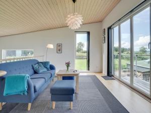 AsperupHoliday Home Lyly - 100m from the sea in Funen by Interhome的客厅配有蓝色的沙发和桌子