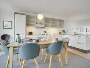 阿森斯Apartment Lucjan - 50m from the sea in Funen by Interhome的厨房配有木桌和椅子