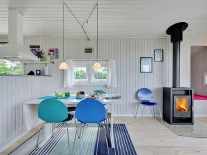 TranekærHoliday Home Raija - 400m from the sea in Funen by Interhome的厨房配有蓝色的椅子、桌子和炉灶