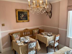 克罗默Albury House的一间带2张桌子和吊灯的用餐室