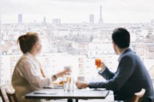 科隆布KOPSTER Hotel Residence Paris Ouest Colombes的两人坐在桌子上喝着饮料