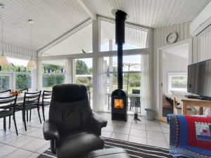 TranekærHoliday Home Caia - 375m from the sea in Funen by Interhome的客厅设有壁炉、桌子和椅子