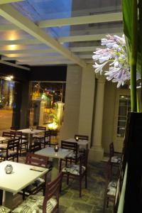 圣达菲Ambit Boulevard Hotel Boutique的一间带桌椅的餐厅以及一朵花