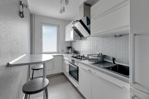 格丁尼亚Comfort Apartments Falista的厨房配有白色橱柜、水槽和柜台。