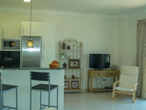 内尔哈Nerja Paradise Rentals - City Center Apt Plaza España的厨房配有柜台、电视和椅子