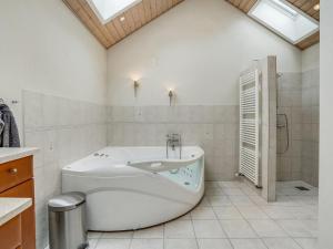 里伯Holiday Home Birita - 20km from the sea in Western Jutland by Interhome的白色的浴室设有浴缸和淋浴。