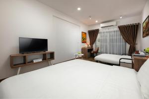河内Hanoi Saga Hotel的配有一张床和一台平面电视的酒店客房