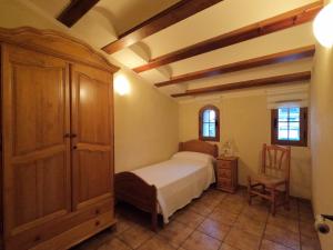 El CastellCAN CALCETER的一间卧室配有一张床、一个橱柜和一把椅子