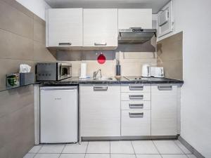 蒙特勒Quiet & Comfy apartment on Av du Casino的厨房配有白色橱柜和白色冰箱。