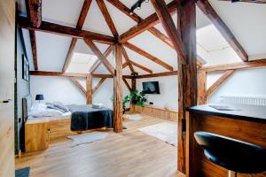 热舒夫VIP Apartamenty的卧室配有一张床铺,位于带木梁的房间