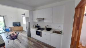 特鲁欧克比赫斯Serenity apartments的白色的厨房设有水槽和炉灶。