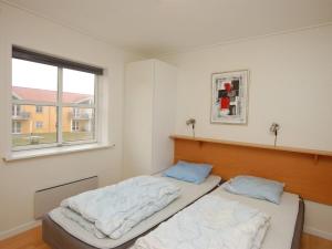 海尔斯Apartment Runhild - 100m from the sea in NE Jutland by Interhome的带窗户的客房内的两张床