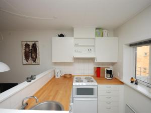 海尔斯Apartment Runhild - 100m from the sea in NE Jutland by Interhome的厨房配有白色橱柜、水槽和炉灶。