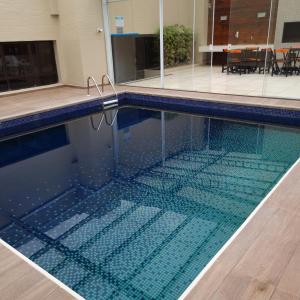 库里提巴Hotel Victoria Villa Curitiba by Nacional Inn的游泳池(带瓷砖地板)和游泳池