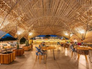江比阿Bamboo Zanzibar的一间带桌椅和大型天花板的餐厅
