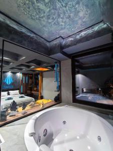 斯科普里Smart Luxury Penthouse Suites - Private Sauna, Hot-Tub, Home Cinema at the best Location in Skopje的卧室内设有一个大浴缸