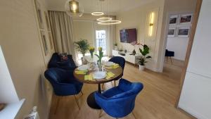 托伦Apartament Nr 50, 2 sypialnie, wygodny parking podziemny的一间带桌子和蓝色椅子的用餐室